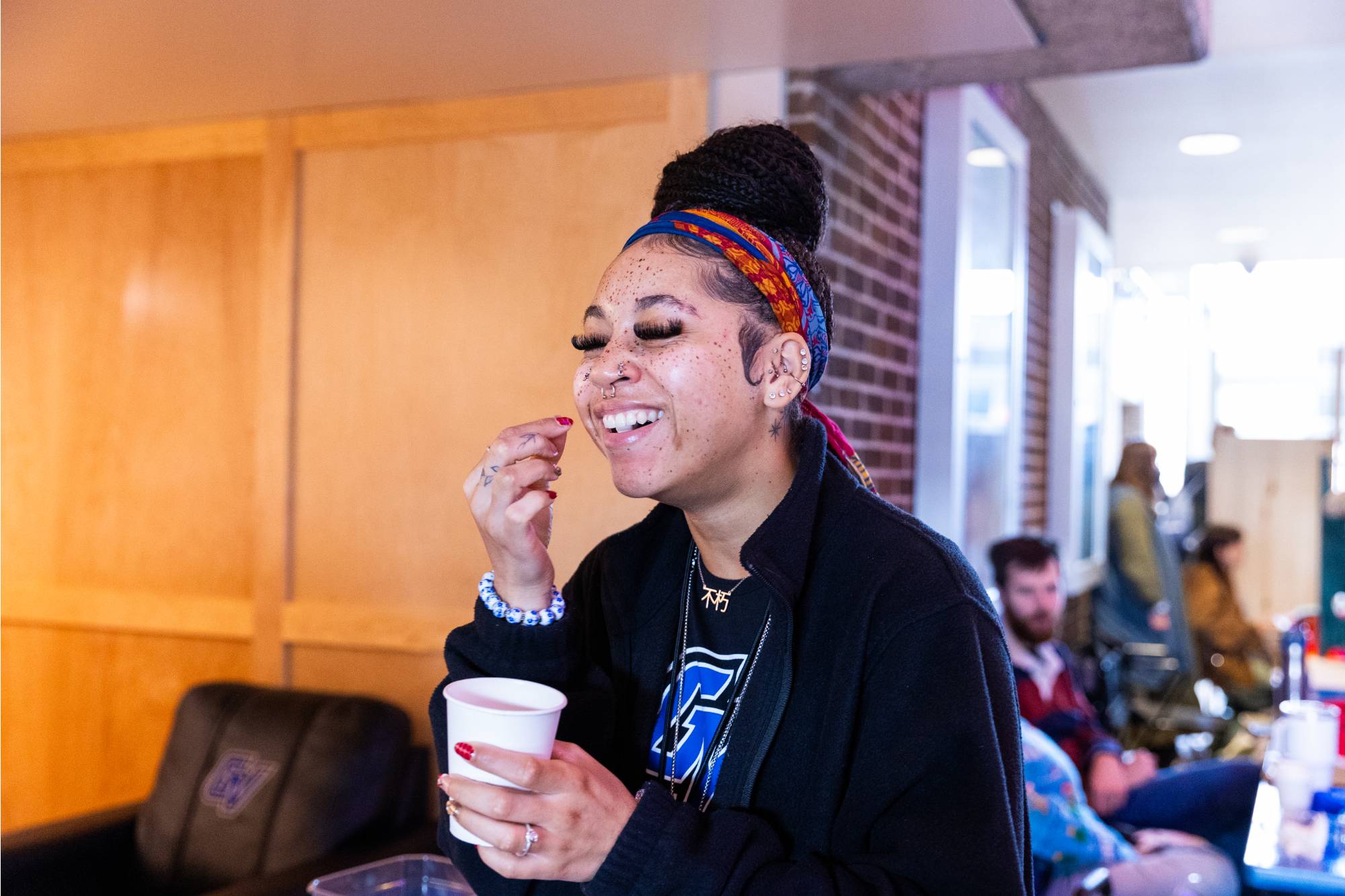 student holding cup laughing
